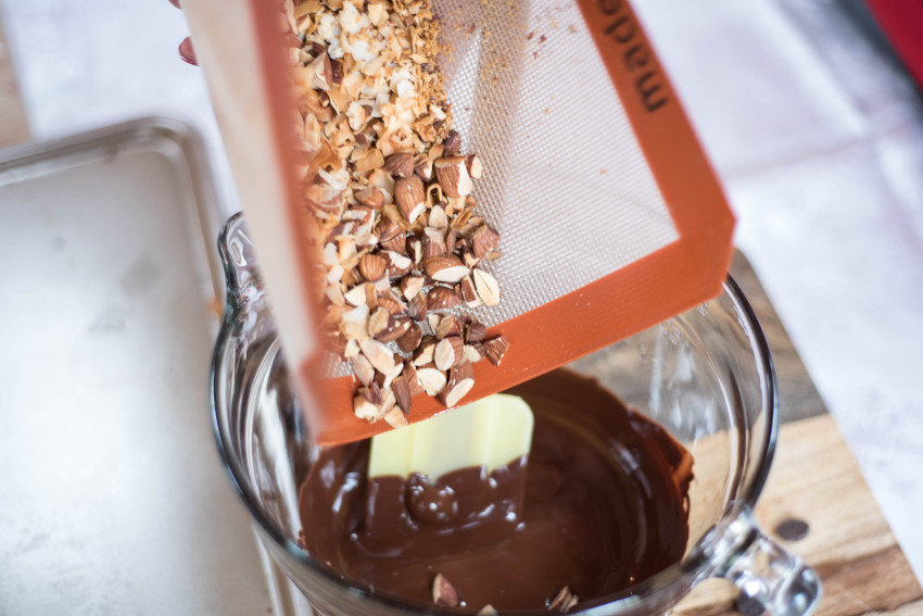 Chocolate Drops Pouring Almonds into CHocolate